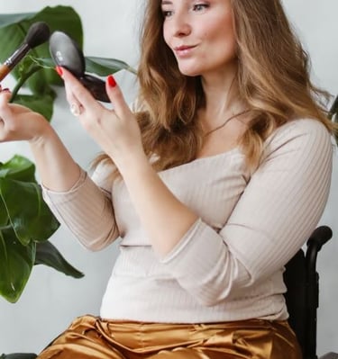 Women in a wheelchair applies makeup to her face