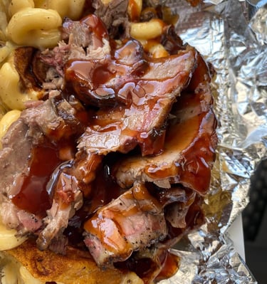 Signature One Eye Willy brisket mac and cheese—Texas-style smoked brisket over four-cheese macaroni with BBQ drizzle, served 