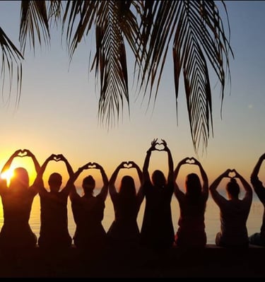 a group of people standing in front of a sunset on their perect gorup vacation
