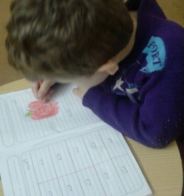a young boy is writing numbers on a paper
