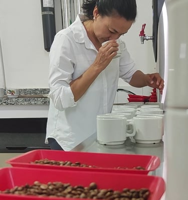a woman in a white shirt and red trays of chocolate covered with chocolate