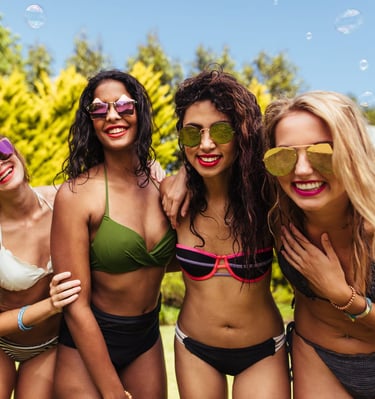 Group of women smiling and enjoying a sunny Las Vegas pool party