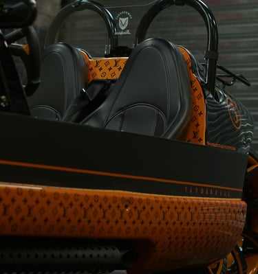 Custom Vanderhall Blackjack three-wheel autocycle with luxury leather seats and orange monogram wrap.