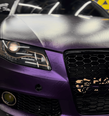 Custom matte purple Audi with a geometric pattern vinyl wrap and honeycomb grille design.