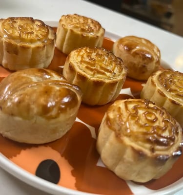 月餅成品 「金黃酥脆的月餅整齊排列於白色盤中，表面印有傳統花紋，展現學生完成作品的成果感與節慶氣氛。