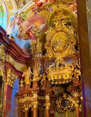 Ornate golden altar and colorful Baroque ceiling frescoes inside Melk Abbey church