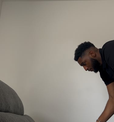 a man is cleaning a couch with a vacuum
