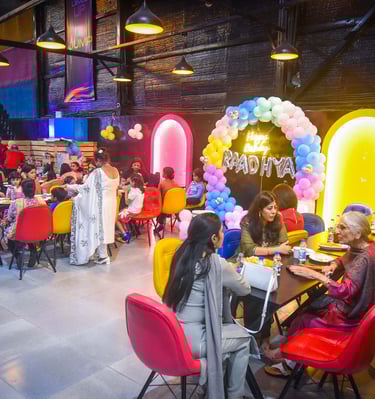 a group of people sitting at tables with balloons