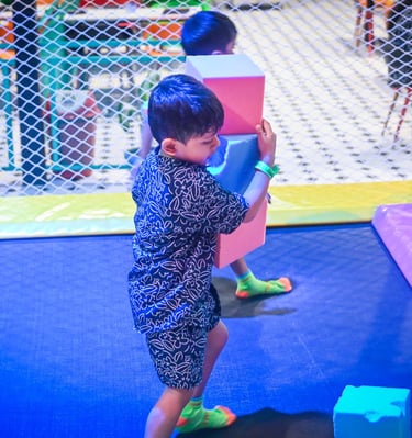 a young boy playing with blocks on a trampoline