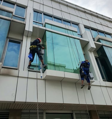 two men are hanging from a building while another man is hanging off the side of