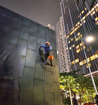 a man on a rope rope with a bucket on a building