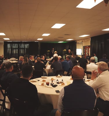 a group of people sitting at tables in a room for an event