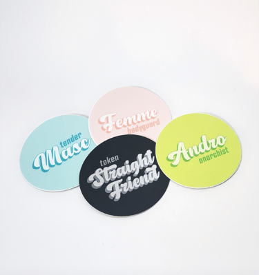 a pile of four stickers with queer identity themes