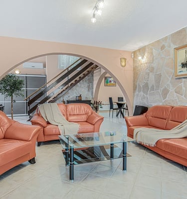 Spacious living room in Villa Nika on the island of Brač with a sofa, loveseat, armchair, and relaxi