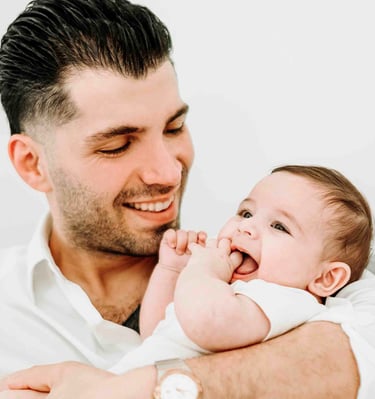 Father smiling while holding baby – Fred Art Studio family session