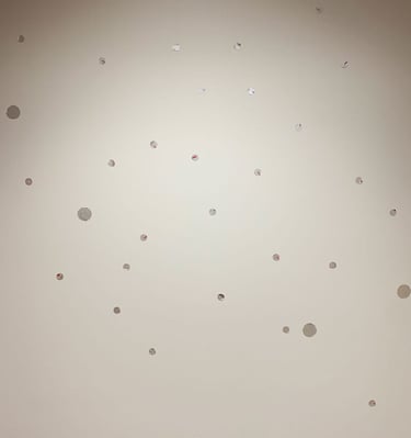 Fun yet elegant silver dot decals are spread over a white wall