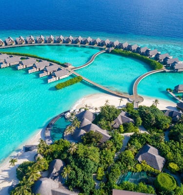 Overwater villas in the Maldives with clear blue lagoon and tropical scenery.