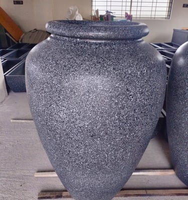 a group of three large vases with granited stone