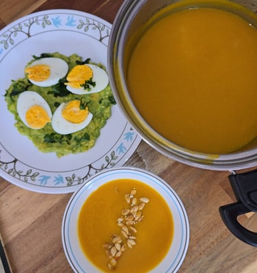 esta es una sopa de zappallo acompañando con un plato plano con aguacate en cama y huevoscocidos