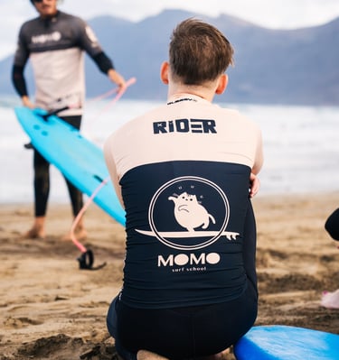 un rider de momo surf school entrain de écouter son cours théorique de surf