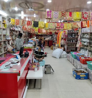 Interior of a Hindu puja store selling spiritual items, deity statues, and colorful religious fabrics.