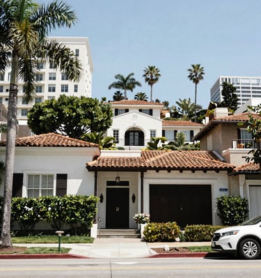A quiet Bel Air street lined with elegant homes, featuring a tasteful belairre.com sales sign near the sidewalk.