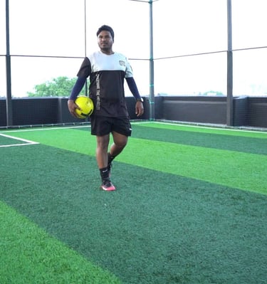 a man in a black shirt and shorts playing soccer