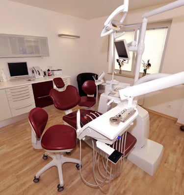 a dental room with a chair and a desk