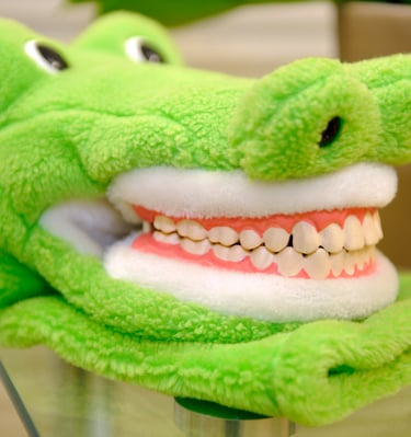 a green stuffed alligators head with teeth