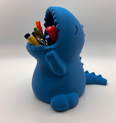 Blue 3D printed dinosaur pencil holder for desk organization featuring colorful pens in its mouth.