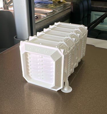 White 3D printed sci-fi shipping container model sitting on a textured printer build plate.