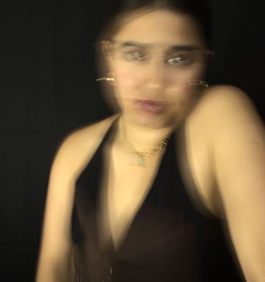 Retrato artístico con desenfoque de movimiento de una mujer con joyeria sobre un fondo oscuro