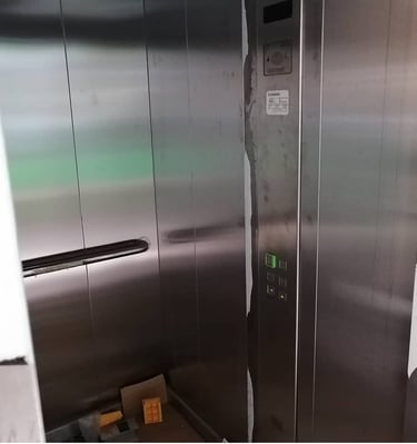 a metal elevator with a metal door and a box of boxes