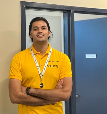 A male employee of Baig Security standing beside a door