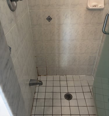 White tiled walk-in shower featuring a faucet, chrome handle, and floor drain for bathroom renovation ideas.
