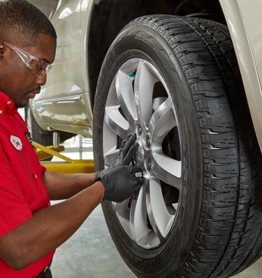 A Big O Tires employee changing a tire
