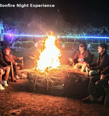 Guests enjoying bonfire night at Jungle Lore Resort in Rishikesh with outdoor seating
