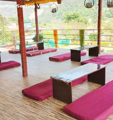 Rooftop seating area at Jungle Lore Resort with mountain view and floor seating