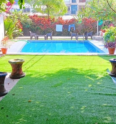 Swimming pool at Jungle Lore Resort with garden and relaxing seating area