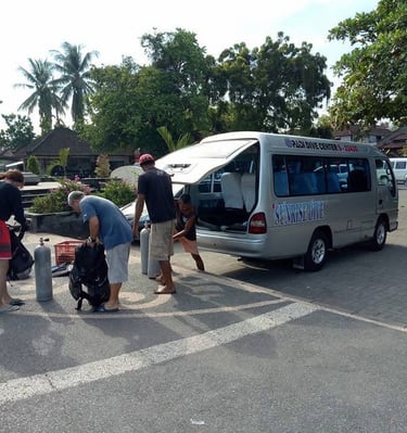 a van with a man in a red shirt and a woman in a red shirt going for diving on central lovina