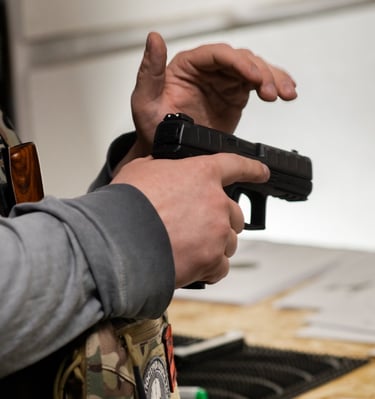 vyras laikantis pistoletą