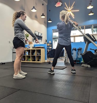 trainer instructing landmine exercise
