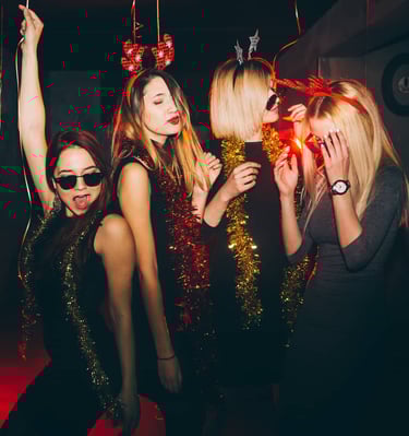 Group of girls enjoying a festive Las Vegas nightlife party, wearing fun holiday accessories and dancing with energy.