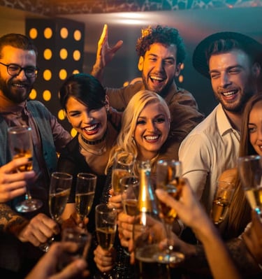 Group of friends toasting with champagne at a lively Las Vegas nightclub, enjoying a festive night out.