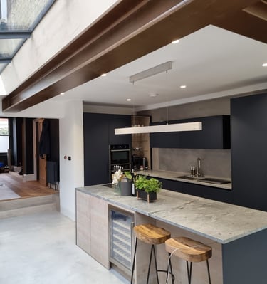 Modern kitchen with matte navy cabinets and exposed beams, painted by Pure Perfection on Balham