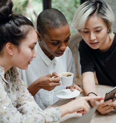 3 young women looking at phone