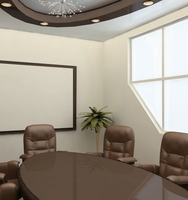 Professional meeting room with a wall-mounted projection screen and executive seating.