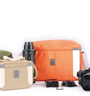 A collection of camera bags and equipment displayed against a white background. 