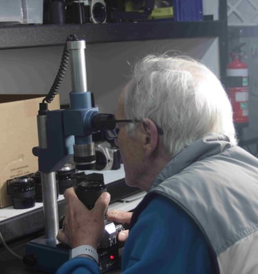 A technician carrying out focus adjustment and recollimation on a Canon camera