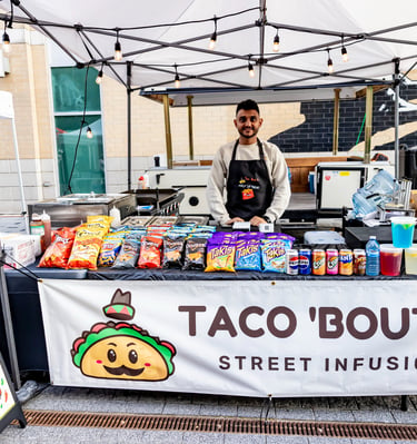 Street food vendor at Afro Fiesta Festival selling walking tacos and snacks under a white tent.